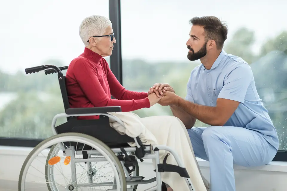 Caregiver talking with a patient in a wheelchair
